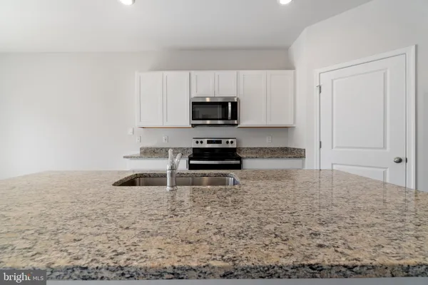 a kitchen with granite countertop a stove and a sink