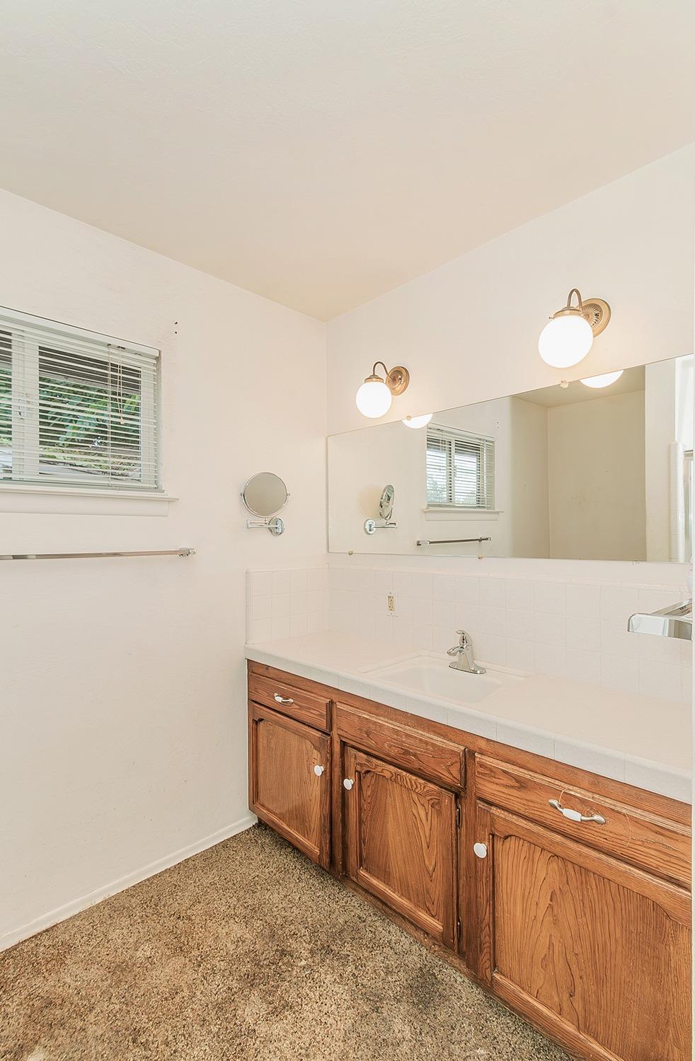 5662 North McCall Avenue Clovis, CA 93619 - Photo 20 of 34 a spacious bathroom with a sink and a mirror