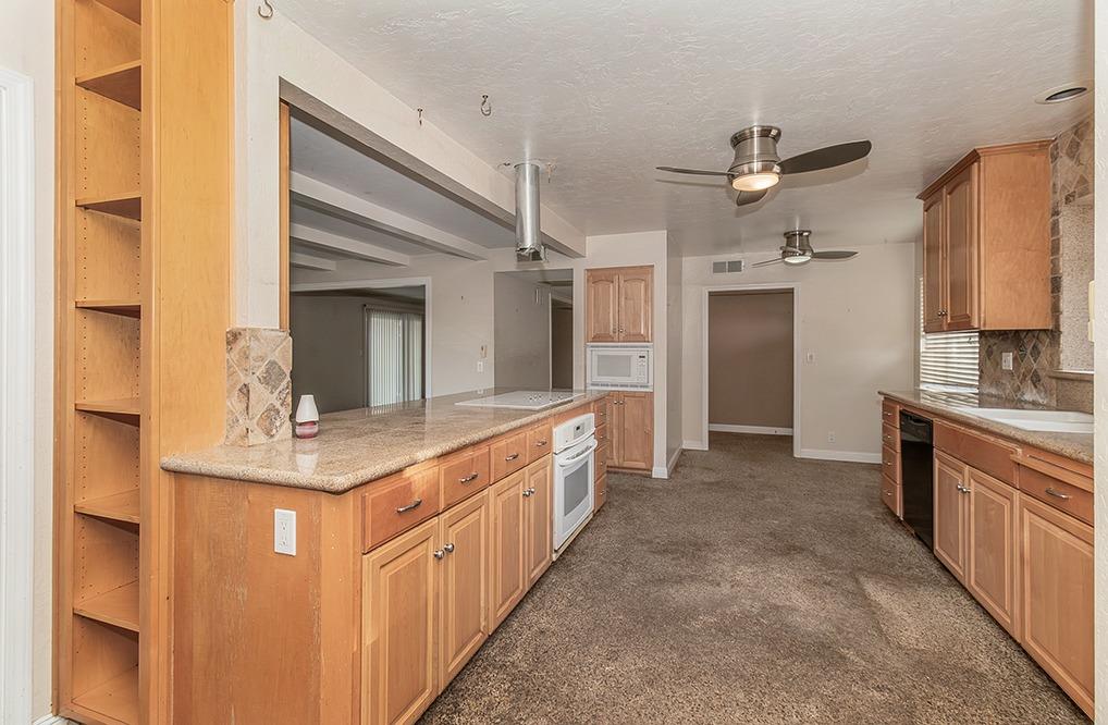 5662 North McCall Avenue Clovis, CA 93619 - Photo 9 of 34 a large kitchen with kitchen island a sink stainless steel appliances and cabinets