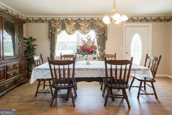 a view of a dining room with furniture a chandelier and wooden floor