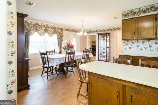 a view of a dining room with furniture a chandelier and wooden floor