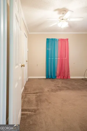 a view of a room with window and a chandelier fan