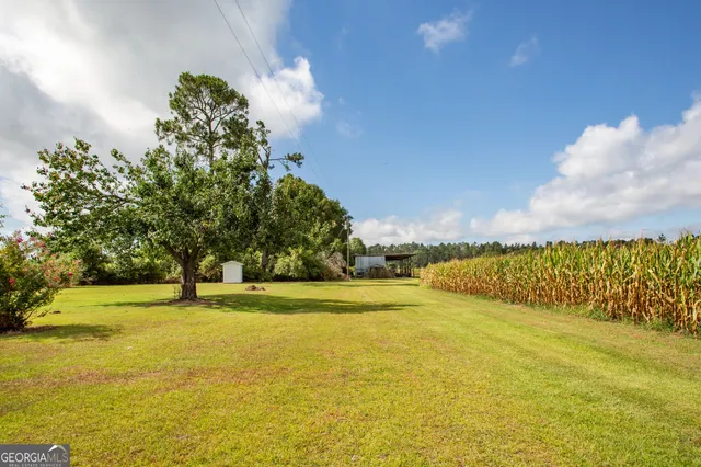 a white house with a big yard and large trees