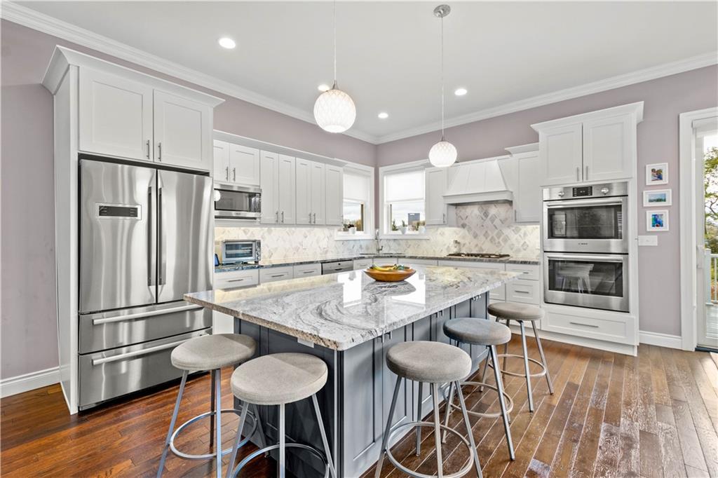 225 Meridan Street Pittsburgh, PA 15211 - Photo 6 of 25 a kitchen with stainless steel appliances a table and chairs in it