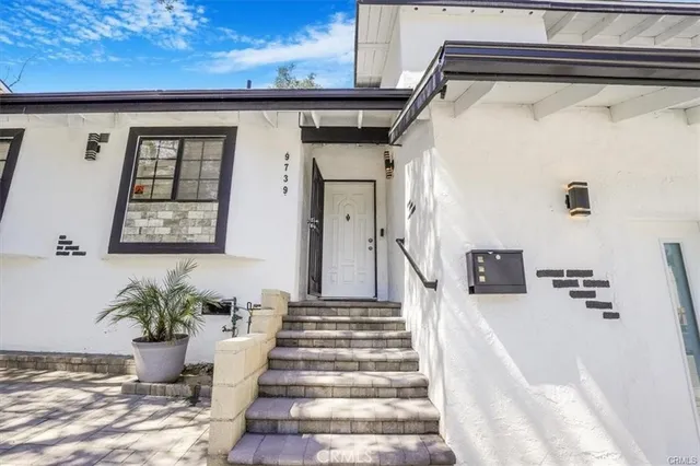 a view of a hallway with wooden floor and a potted plant