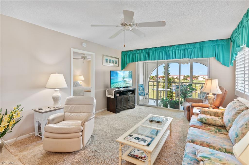 29 High Point Circle East, Unit 508 Naples, FL 34103 - Photo 6 of 35 a living room with furniture a rug potted plant and a large window