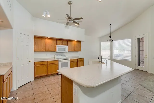 a large kitchen with kitchen island granite countertop a sink window and cabinets