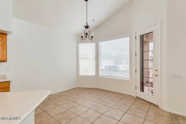 an empty room with ceiling fan and window