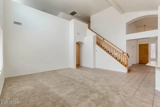 an empty room with a ceiling fan and wooden floor