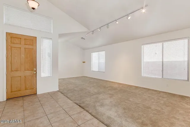 a view of an empty room with a window and closet