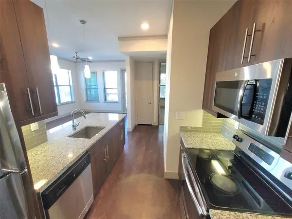 a kitchen with stainless steel appliances granite countertop a sink stove and refrigerator