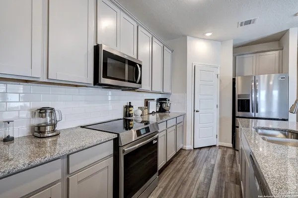 a kitchen with stainless steel appliances granite countertop a stove a sink and a refrigerator