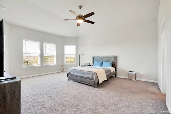 a spacious bedroom with a bed and a large window