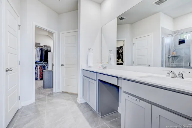 a bathroom with a double vanity sink and a mirror