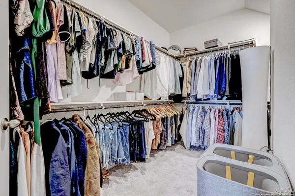 a view of walk in closet with clothes