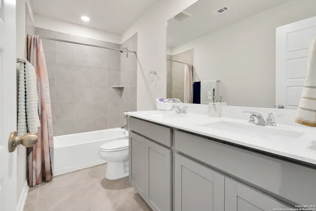 a bathroom with a double vanity sink toilet and shower