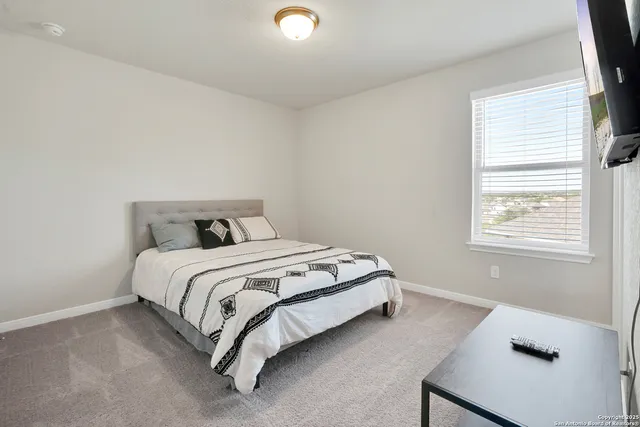 a bed sitting in a bedroom next to a window