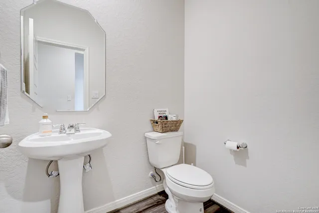 a bathroom with a toilet sink and mirror