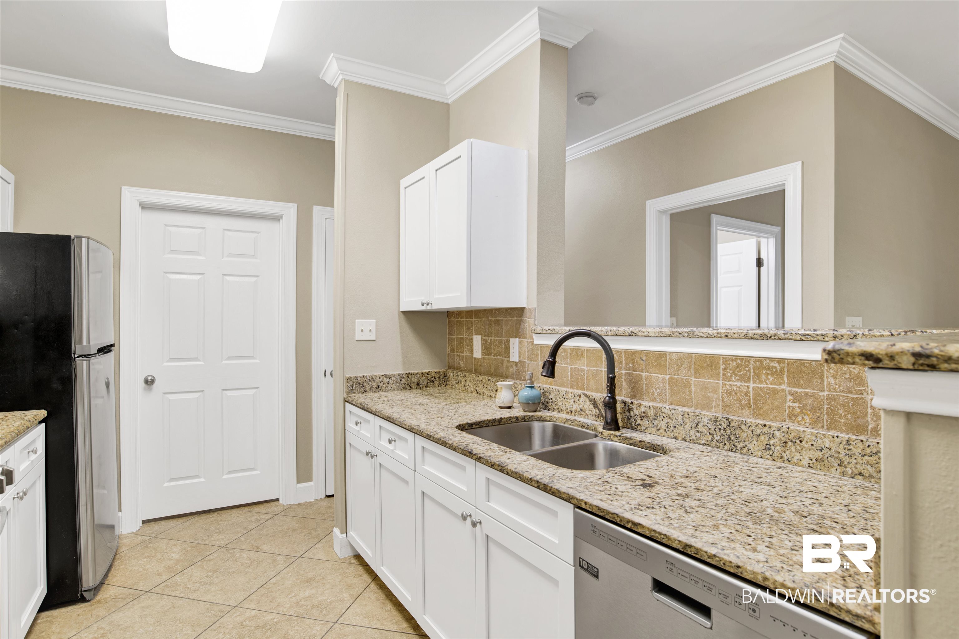 450 Park Avenue, Unit 202 Foley, AL 36535 - Photo 3 of 18 Kitchen with white cabinetry, light stone counters, backsplash, appliances with stainless steel finishes, and light tile patterned floors