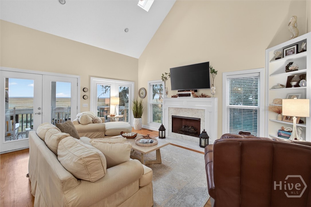 341 Youman's Road Midway, GA 31320 - Photo 7 of 52 Sunlit family room with vaulted ceiling, built-in bookcase, fireplace and expansive marsh views