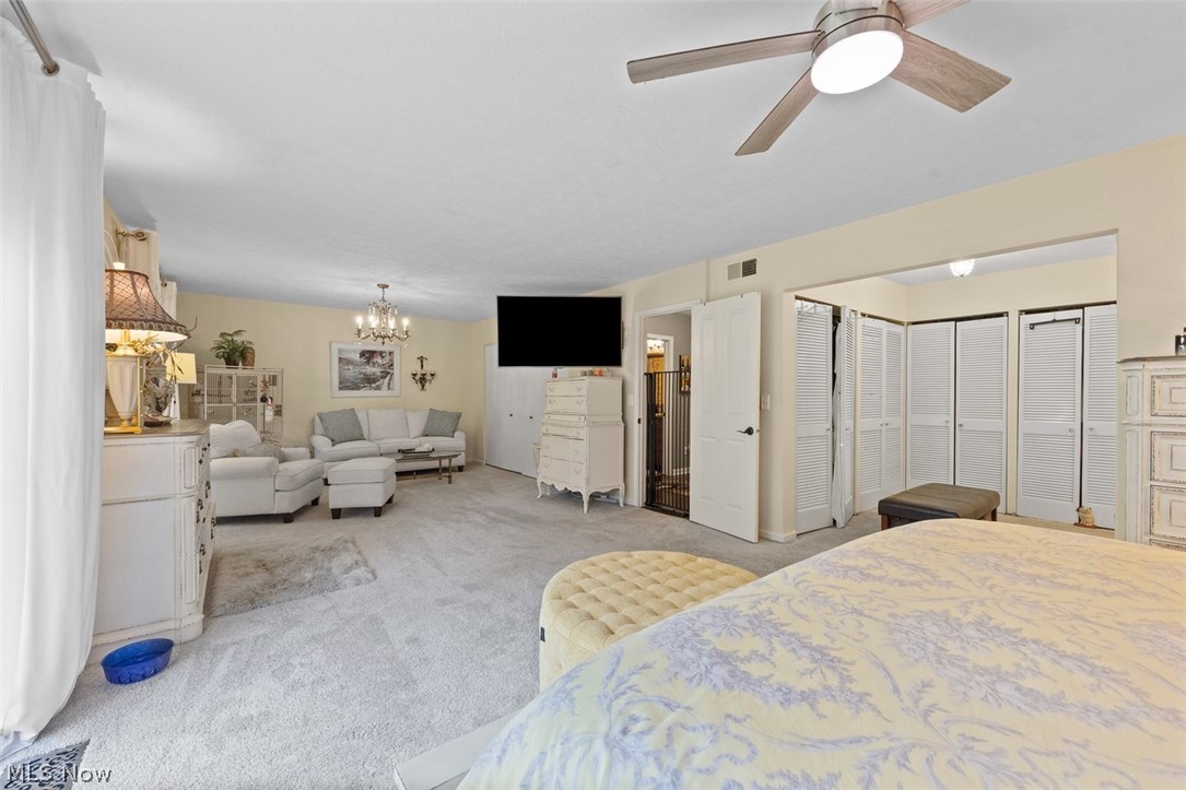 171 Granger Road, Unit 107 Medina, OH 44256 - Photo 26 of 41 Spacious Master interior space featuring Carpet,a ceiling fan with integrated lighting, a chandelier, and multiple white bi-fold closet doors