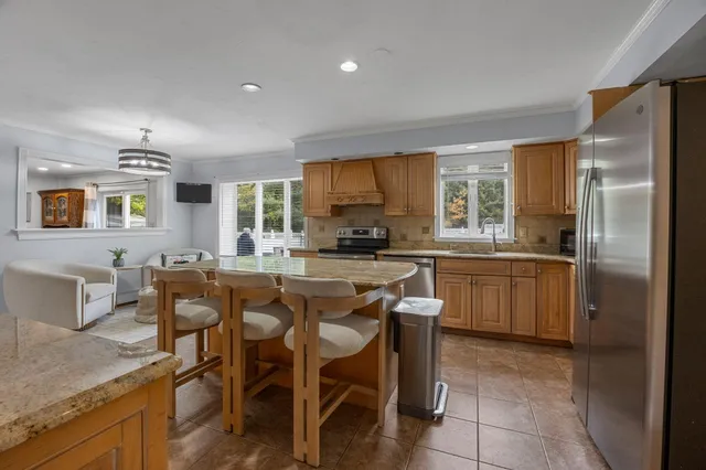 a kitchen with granite countertop stainless steel appliances a table and chairs