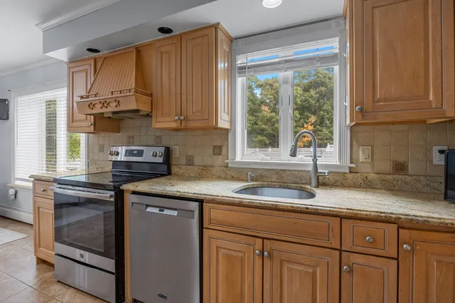 a kitchen with stainless steel appliances granite countertop a sink a stove and a microwave