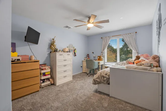 a bedroom with a bed and a flat tv screen on the dresser