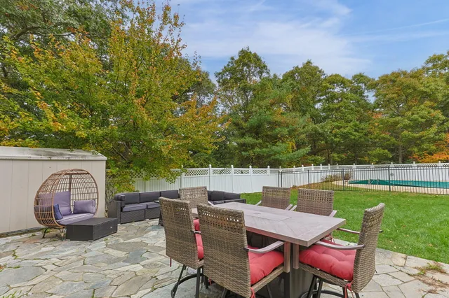 a view of a swimming pool and lounge chairs in back yard of the house