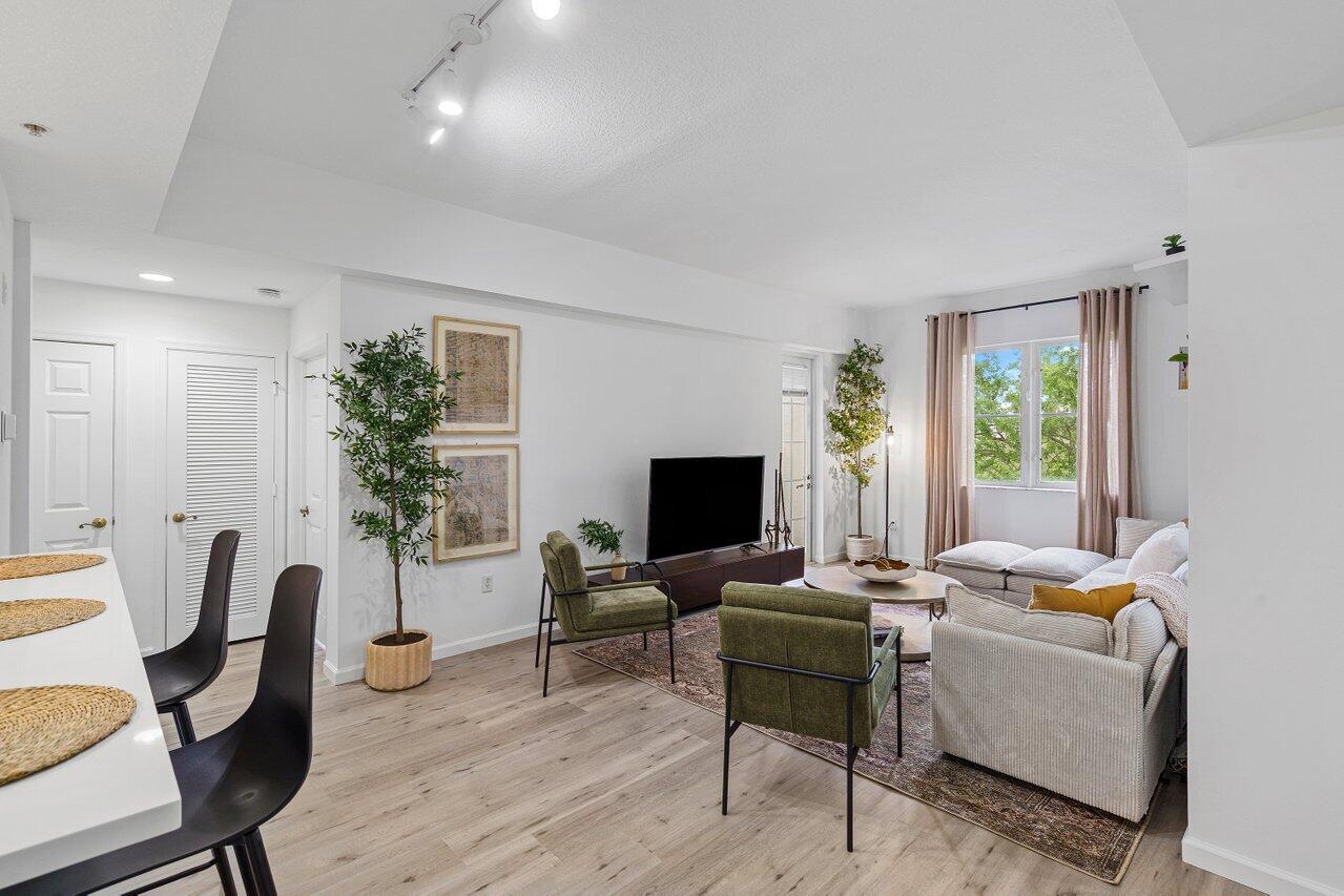 a living room with furniture potted plant a window and a flat screen tv