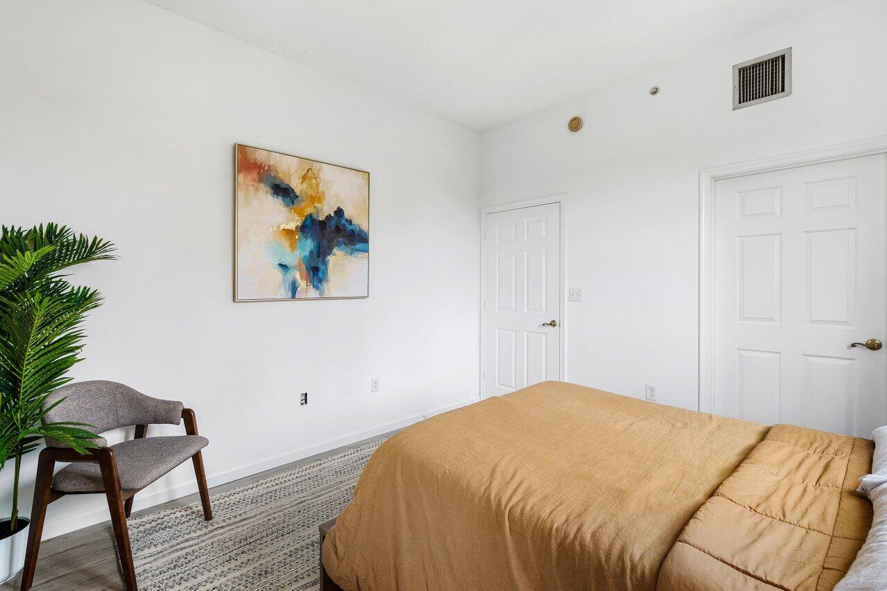 1209 Main Street, Unit 302 Jupiter, FL 33458 - Photo 14 of 35 a bedroom with a bed and a painting on the wall
