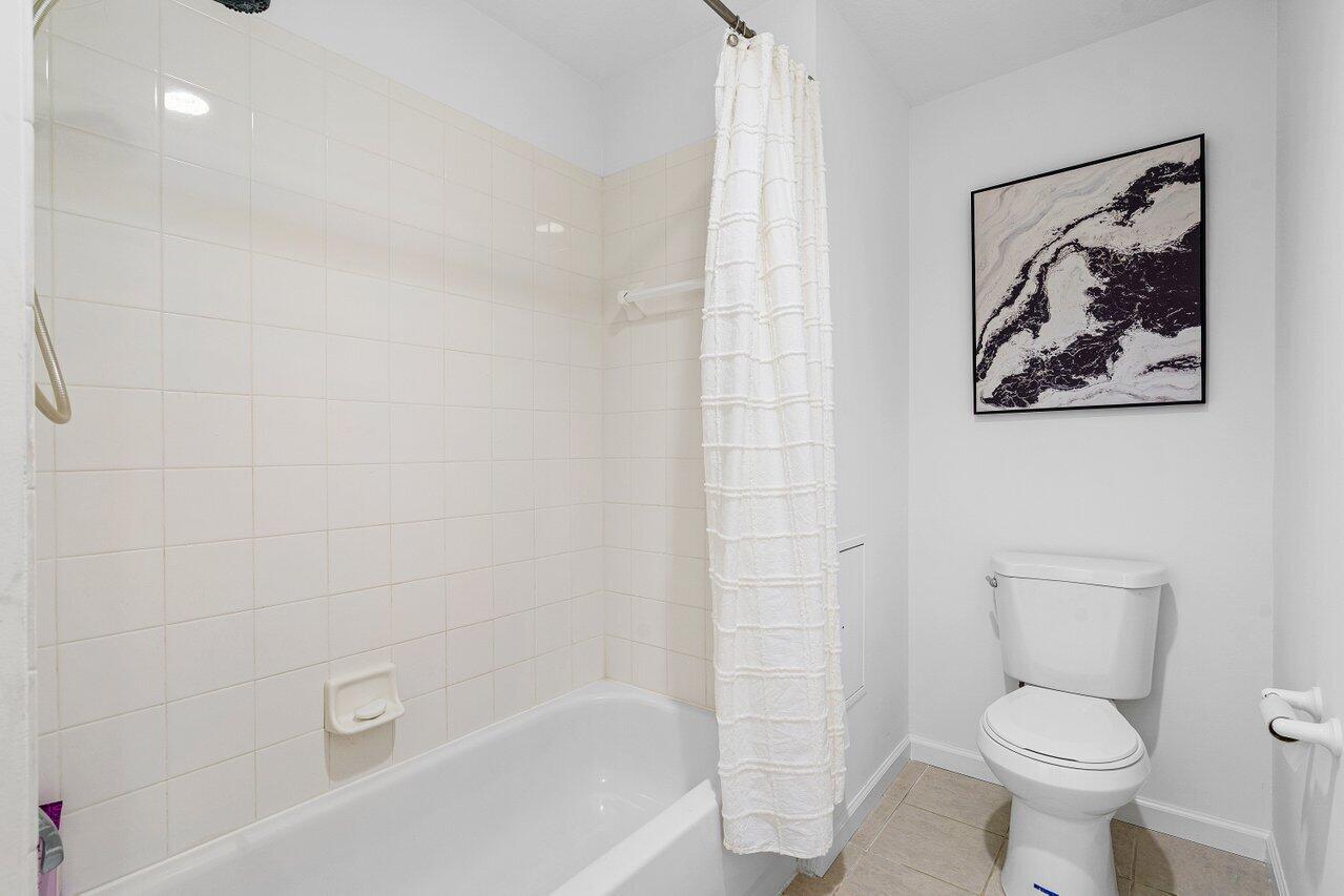 1209 Main Street, Unit 302 Jupiter, FL 33458 - Photo 16 of 35 a white toilet sitting next to a bath tub