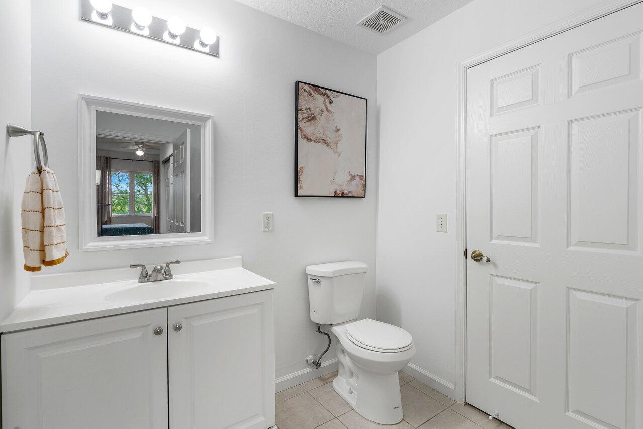 1209 Main Street, Unit 302 Jupiter, FL 33458 - Photo 21 of 35 a bathroom with a toilet sink and mirror
