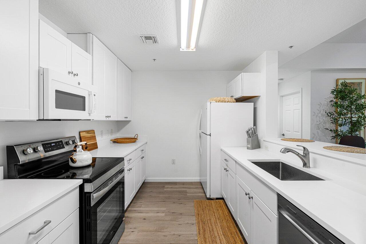 1209 Main Street, Unit 302 Jupiter, FL 33458 - Photo 5 of 35 a kitchen with a sink a stove and cabinets