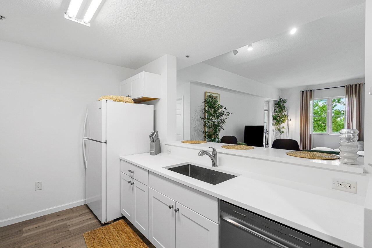 1209 Main Street, Unit 302 Jupiter, FL 33458 - Photo 6 of 35 a kitchen with a sink and a refrigerator