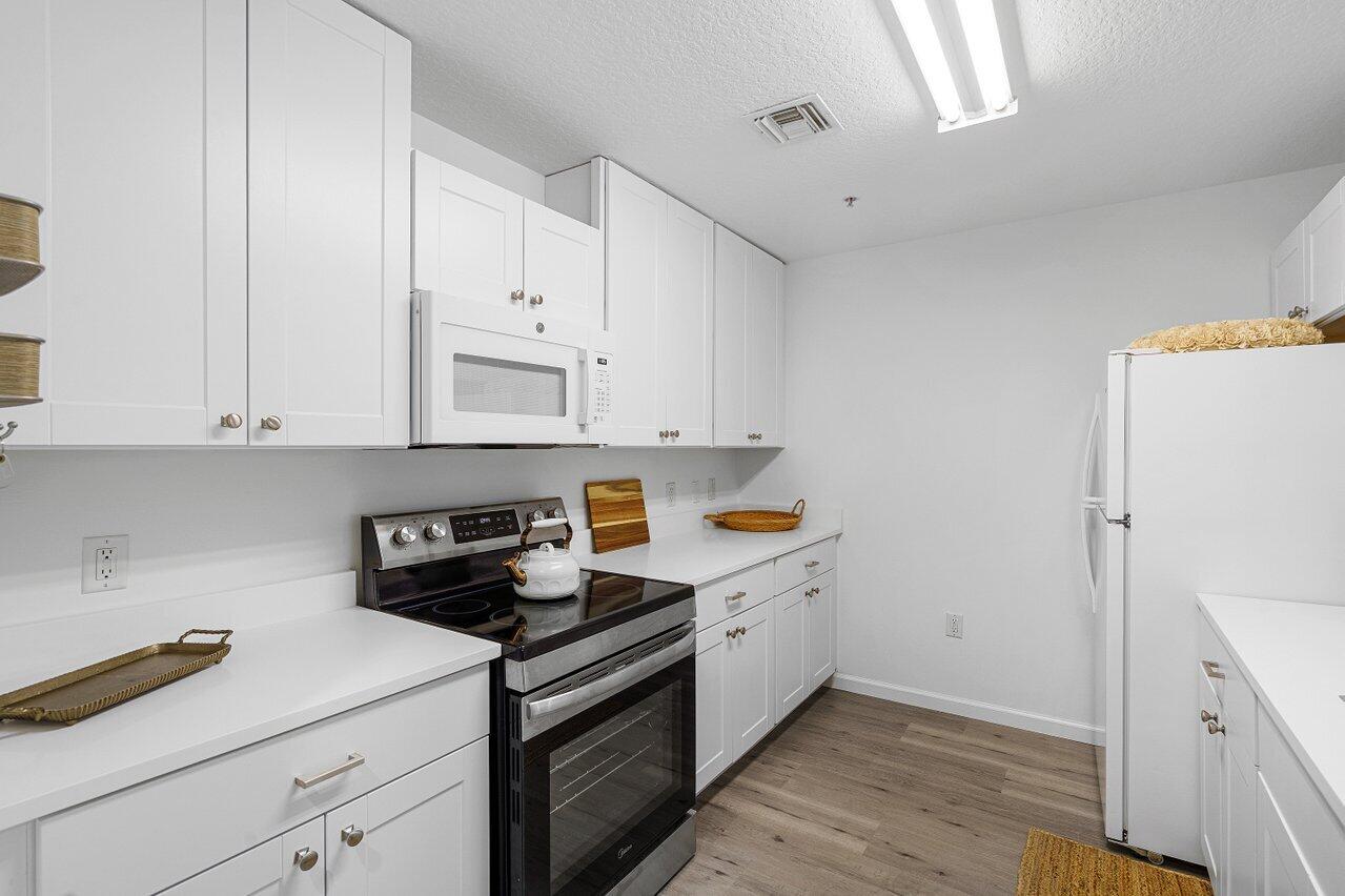 1209 Main Street, Unit 302 Jupiter, FL 33458 - Photo 7 of 35 a kitchen with cabinets and appliances