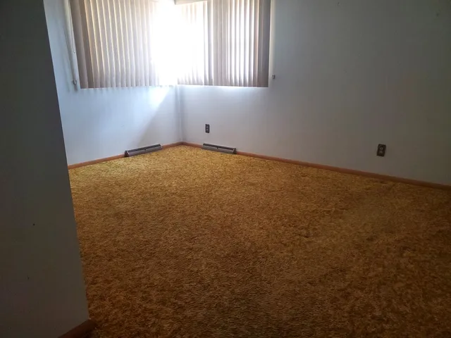 a view of an empty room and wooden floor