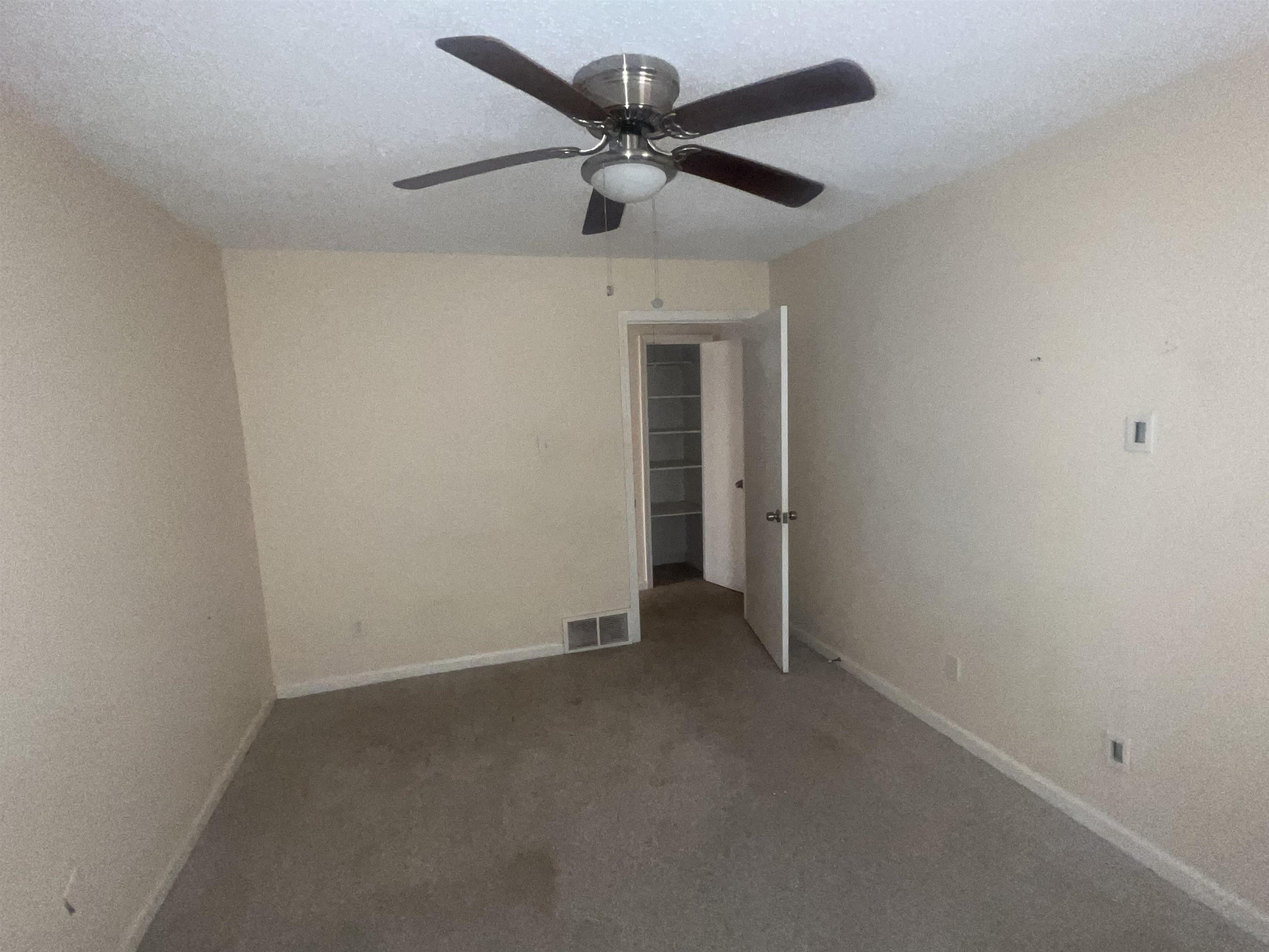 4295 Hudgins Road Memphis, TN 38116 - Photo 9 of 16 Neutral-toned room featuring a ceiling fan with light fixture, textured walls, and carpet flooring