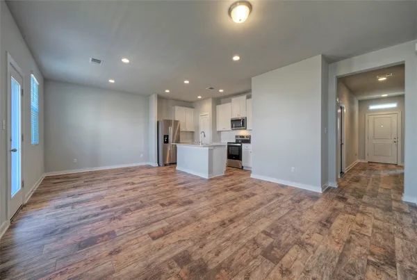 a view of empty room with wooden floor