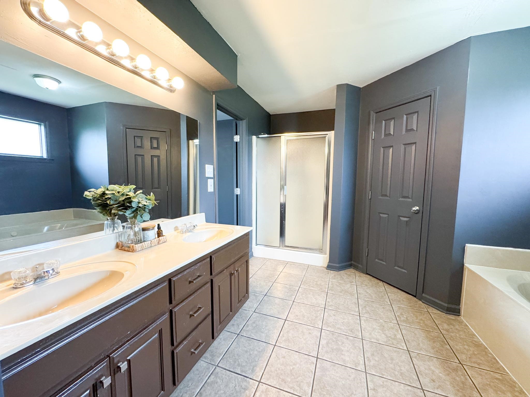 4776 Campground Road Munford, TN 38058 - Photo 18 of 25 a spacious bathroom with a granite countertop sink a mirror and a shower