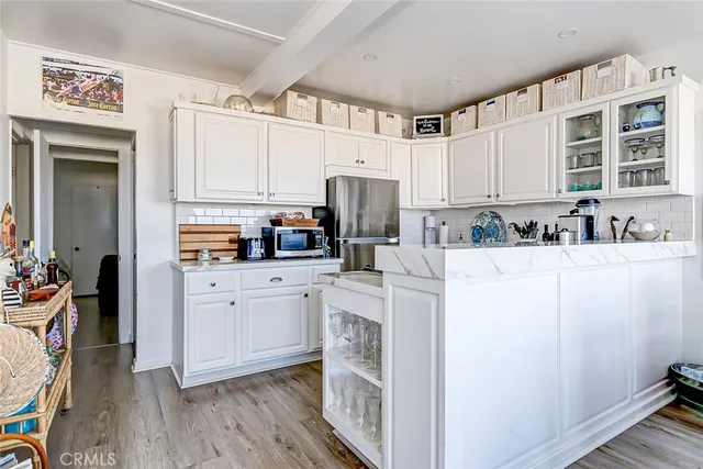 a kitchen with refrigerator cabinets and wooden floor