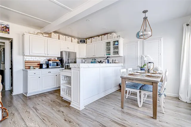 a kitchen with a sink cabinets stainless steel appliances and a dining table view