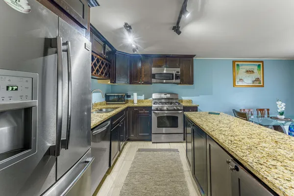a kitchen with stainless steel appliances granite countertop a refrigerator and a sink