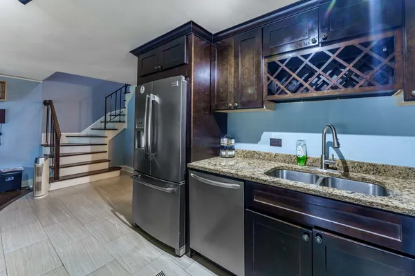 a kitchen with stainless steel appliances granite countertop a refrigerator and a stove top oven