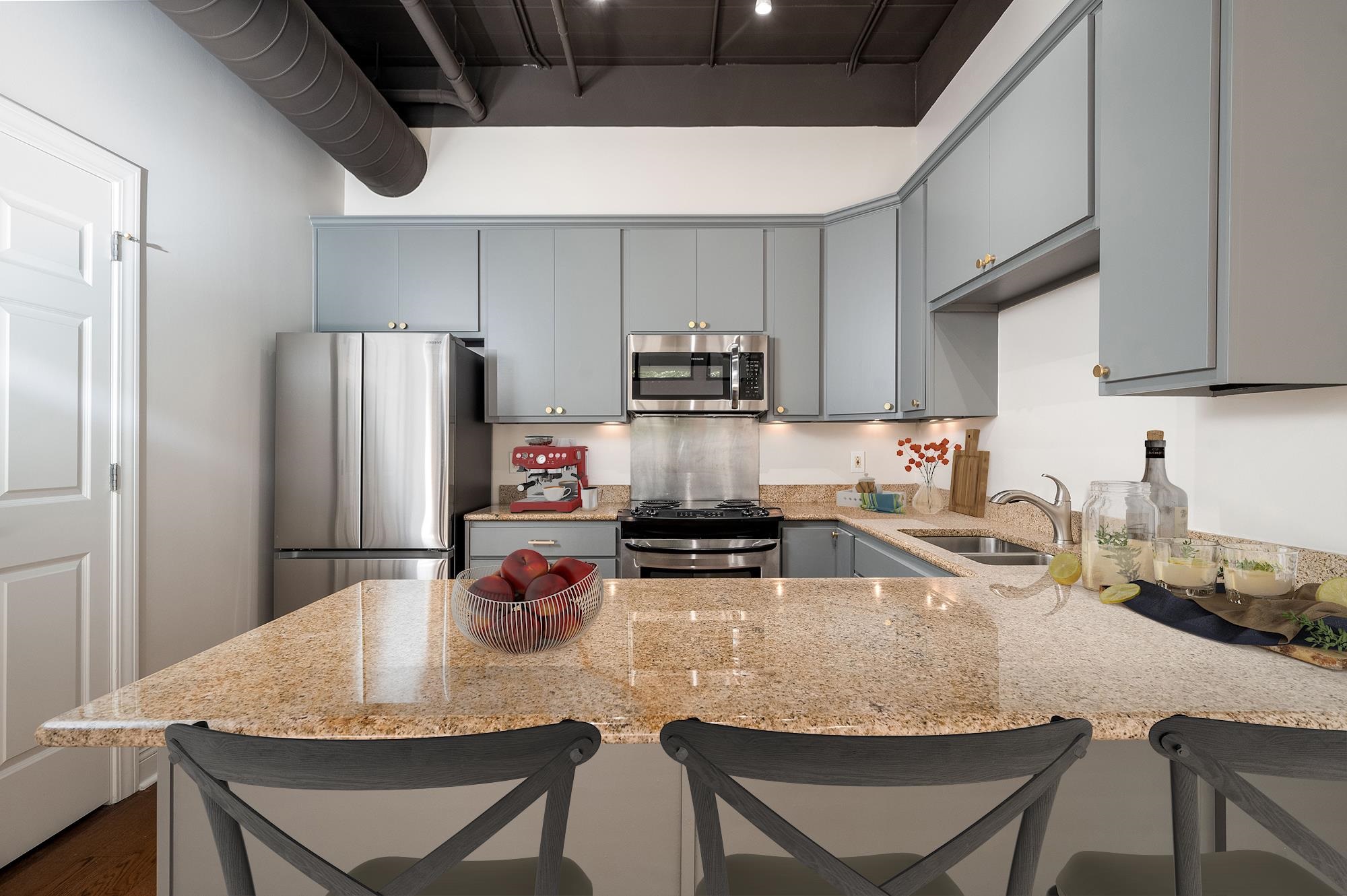 95 South Main Street, Unit 204 Memphis, TN 38103 - Photo 12 of 18 a kitchen with stainless steel appliances granite countertop a kitchen island a stove a refrigerator a sink a dining table and chairs