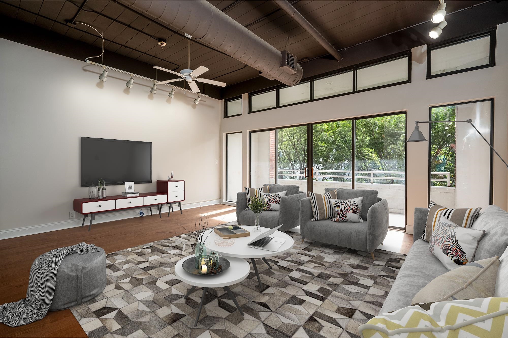 95 South Main Street, Unit 204 Memphis, TN 38103 - Photo 3 of 18 a living room with furniture and a flat screen tv