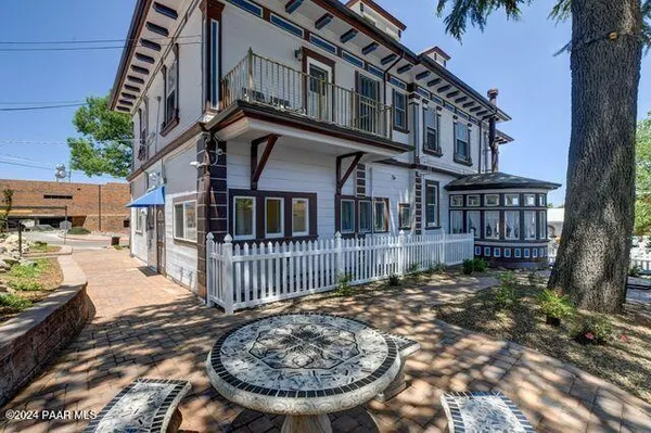 a view of a white house with large windows and a small yard