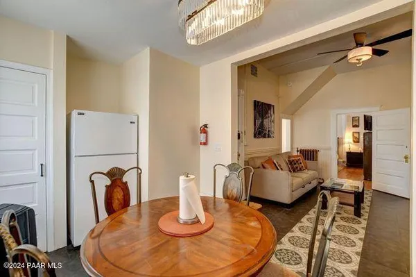 a dining room with couches chairs and wooden floor