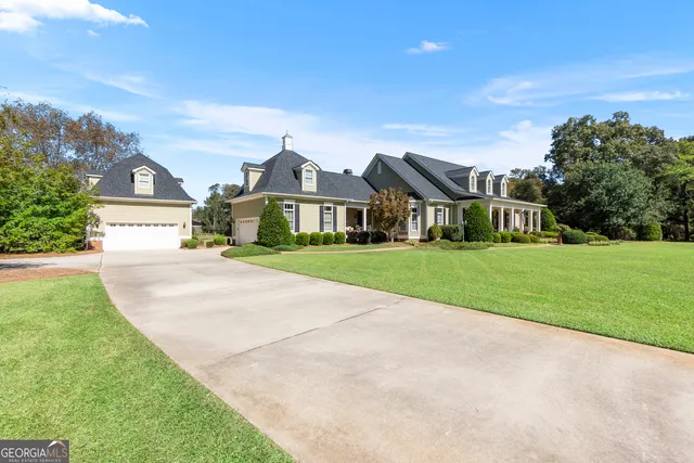front view of a brick house with a yard and potted plants