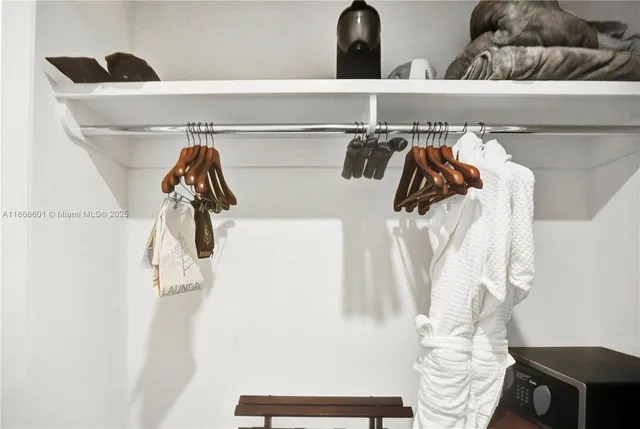 a view of walk in closet with clothes and shoes